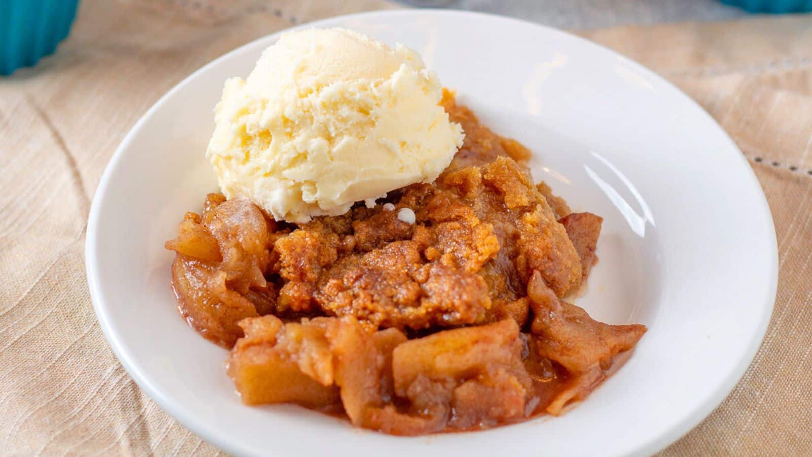 Apple Crumble topped with ice cream on a plate