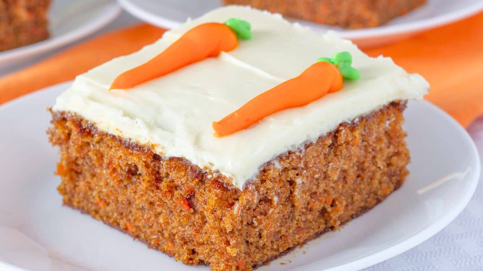 Slice of carrot cake with carrot decorations on top