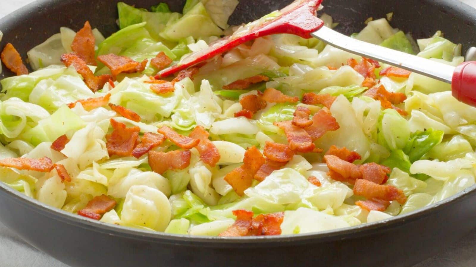 Cabbage and bacon in a pan with a spatula
