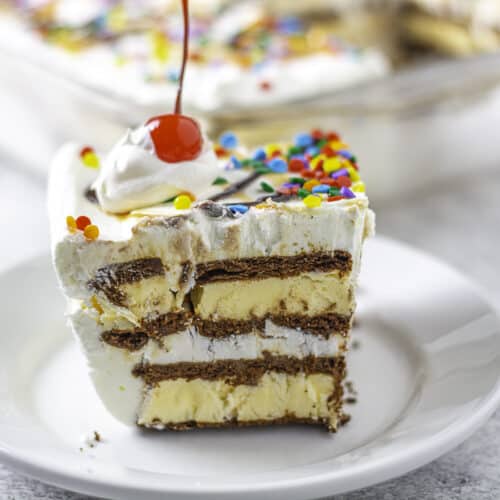Ice cream sandwich cake slice topped with a cherry on a plate