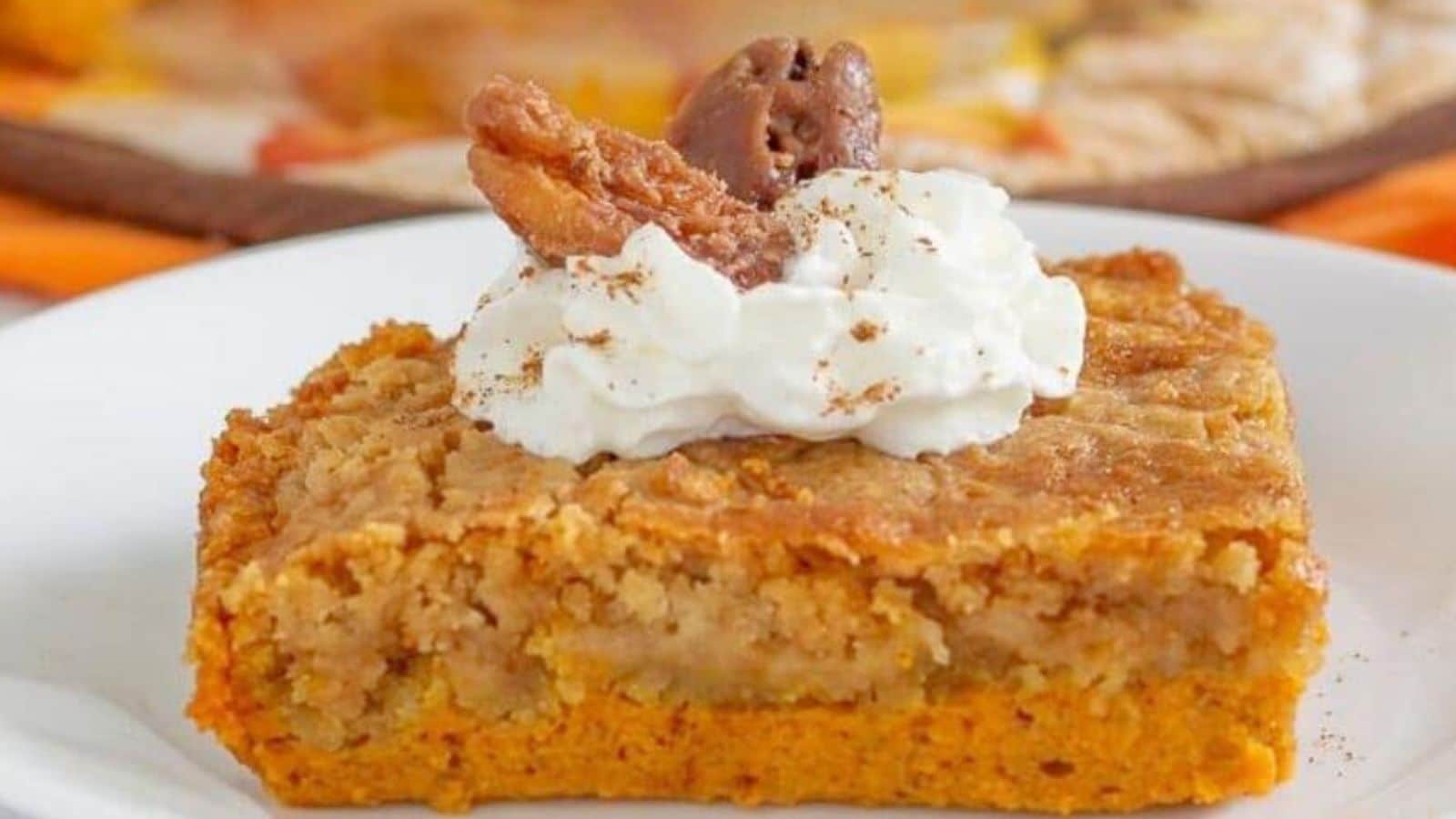 Pumpkin Pie Cake topped with whipped cream and pecan halves