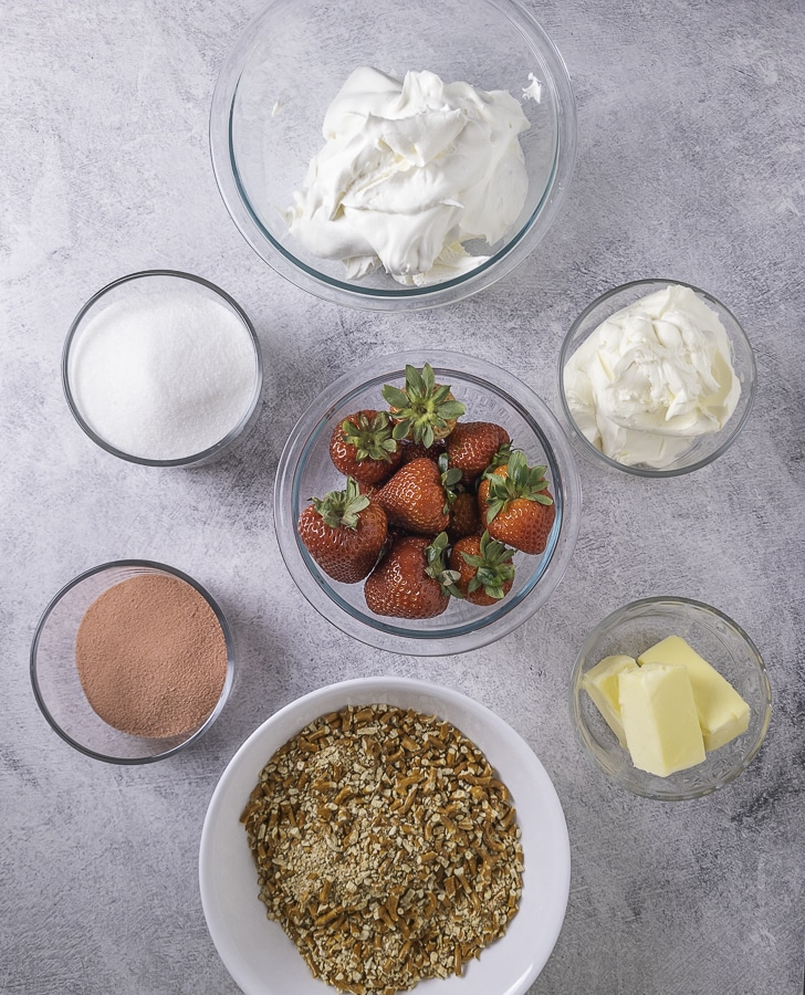 Pretzel crumbs jello mix sugar whipped topping cream cheese butter and strawberries in bowls