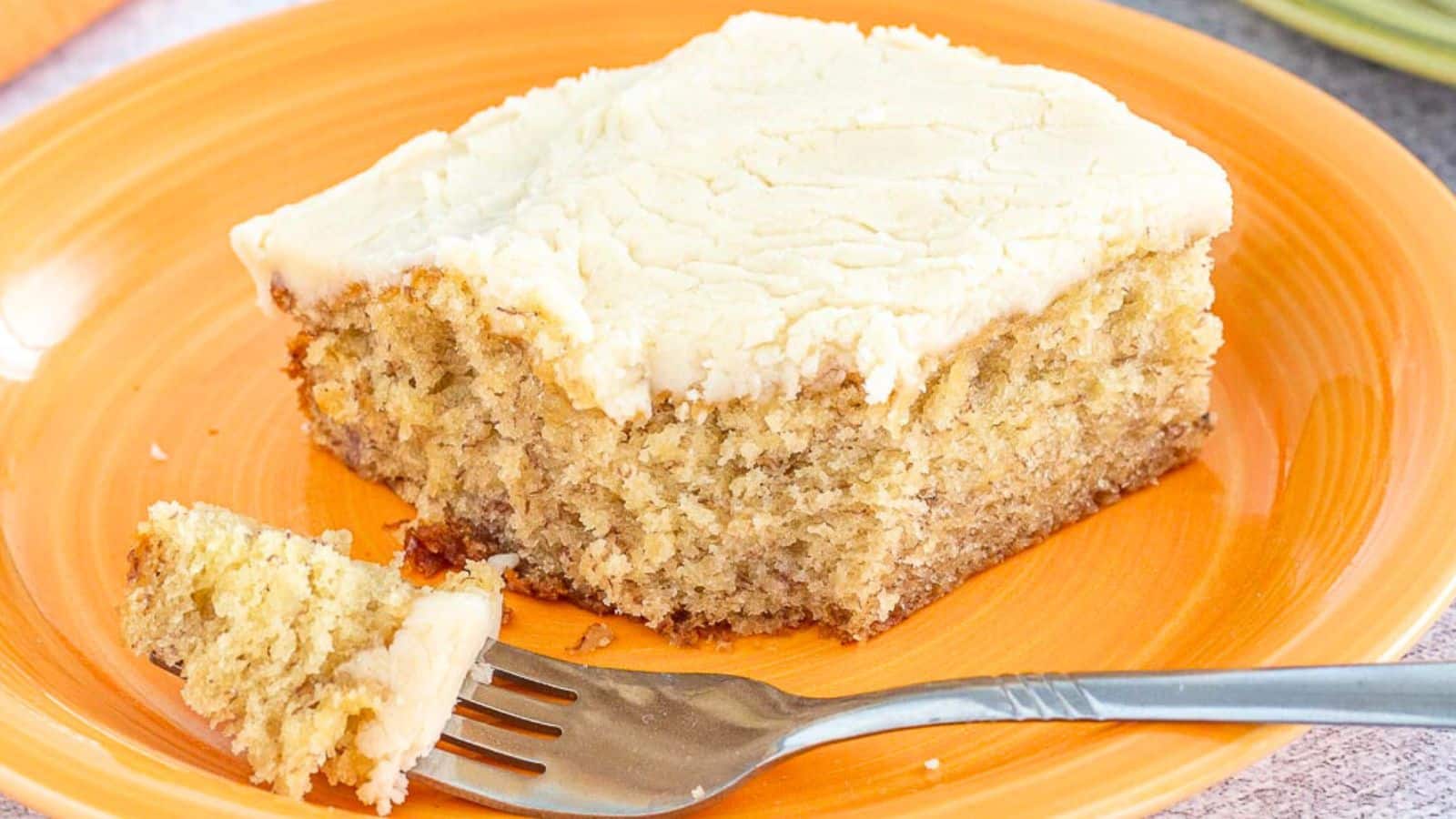 Banana brownie with frosting on a plate with a fork