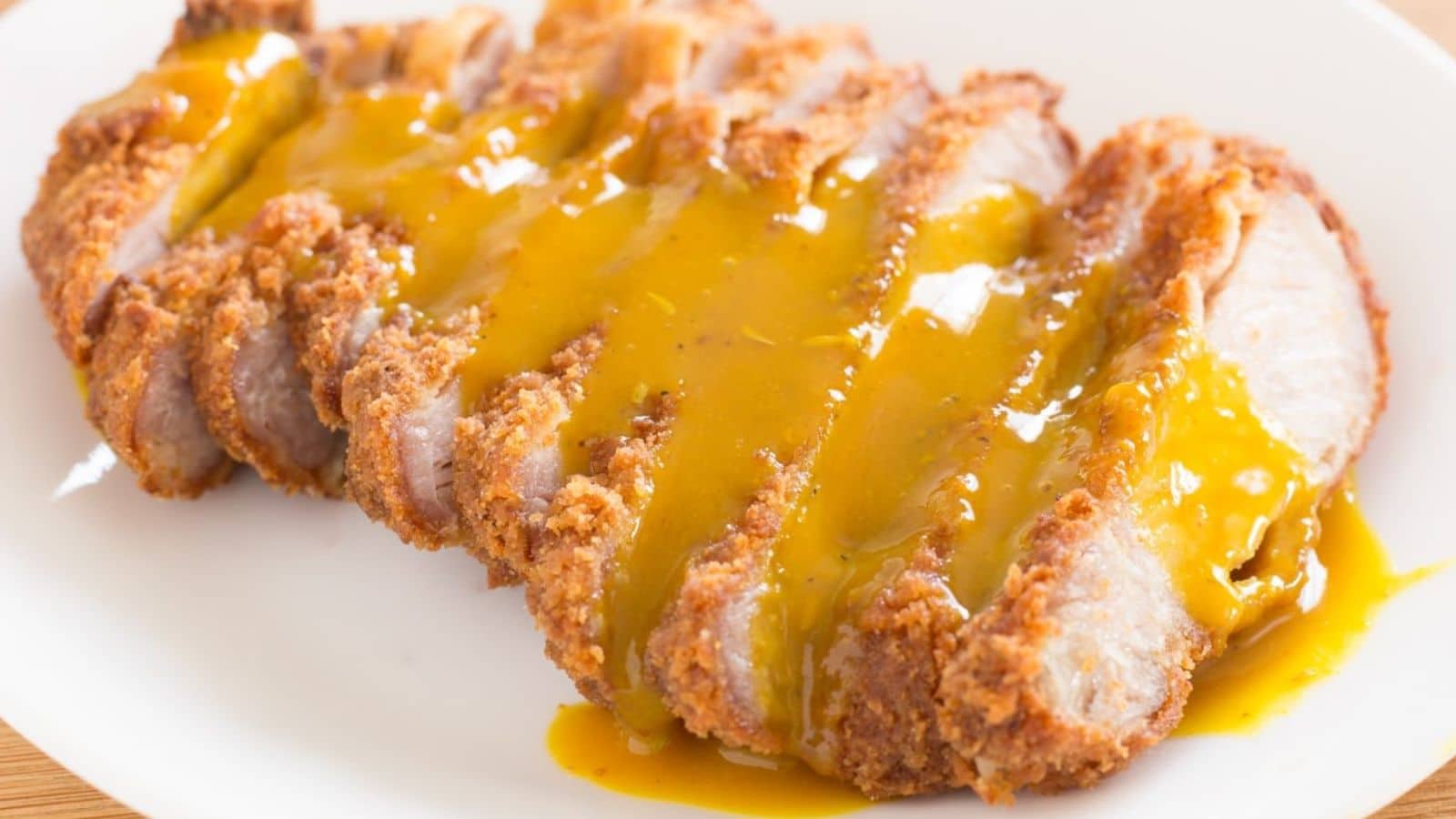 Sliced fried pork chop topped with honey mustard sauce