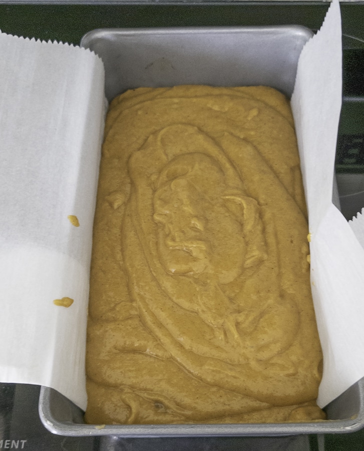 Pumpkin bread batter in a parchment paper lined pan