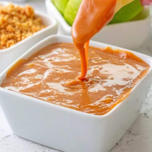 Dipping an apple in caramel sauce