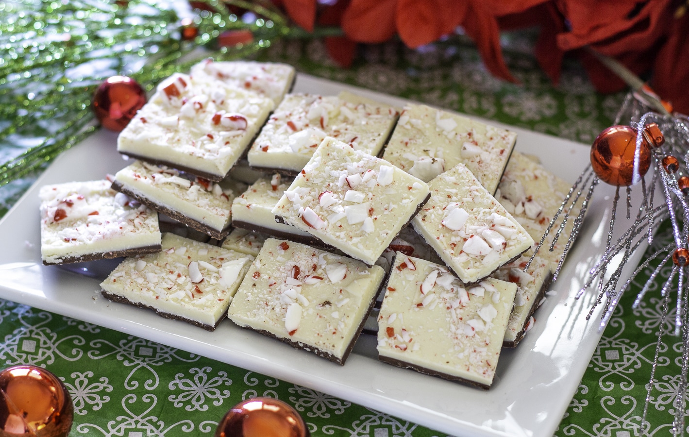 2 layer peppermint bark on a tray surrounded by ornaments