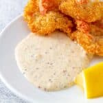 remoulade sauce on a plate with shrimp and a lemon wedge