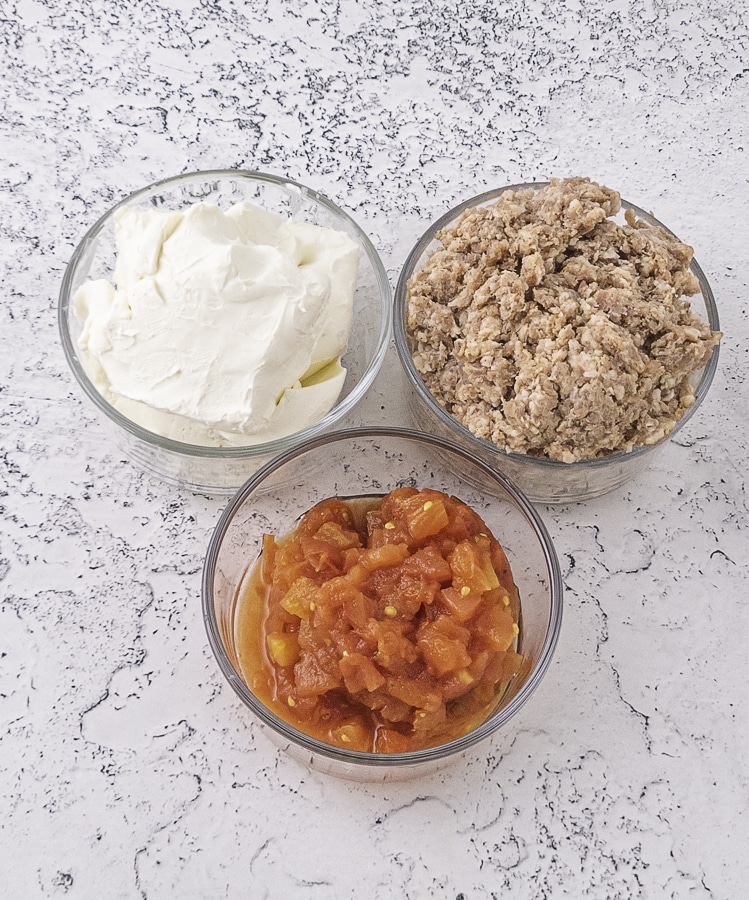 Cream cheese raw sausage and rotel tomatoes in bowls