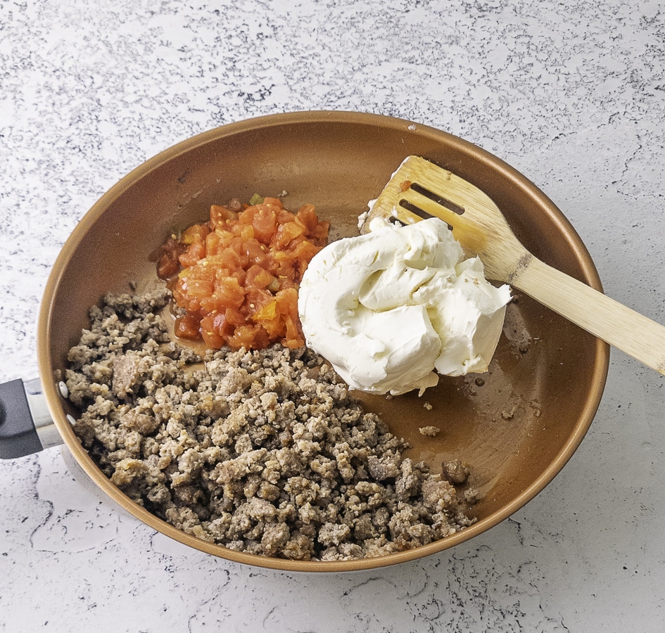 browned sausage cream cheese and drained rotel tomatoes in a skillet
