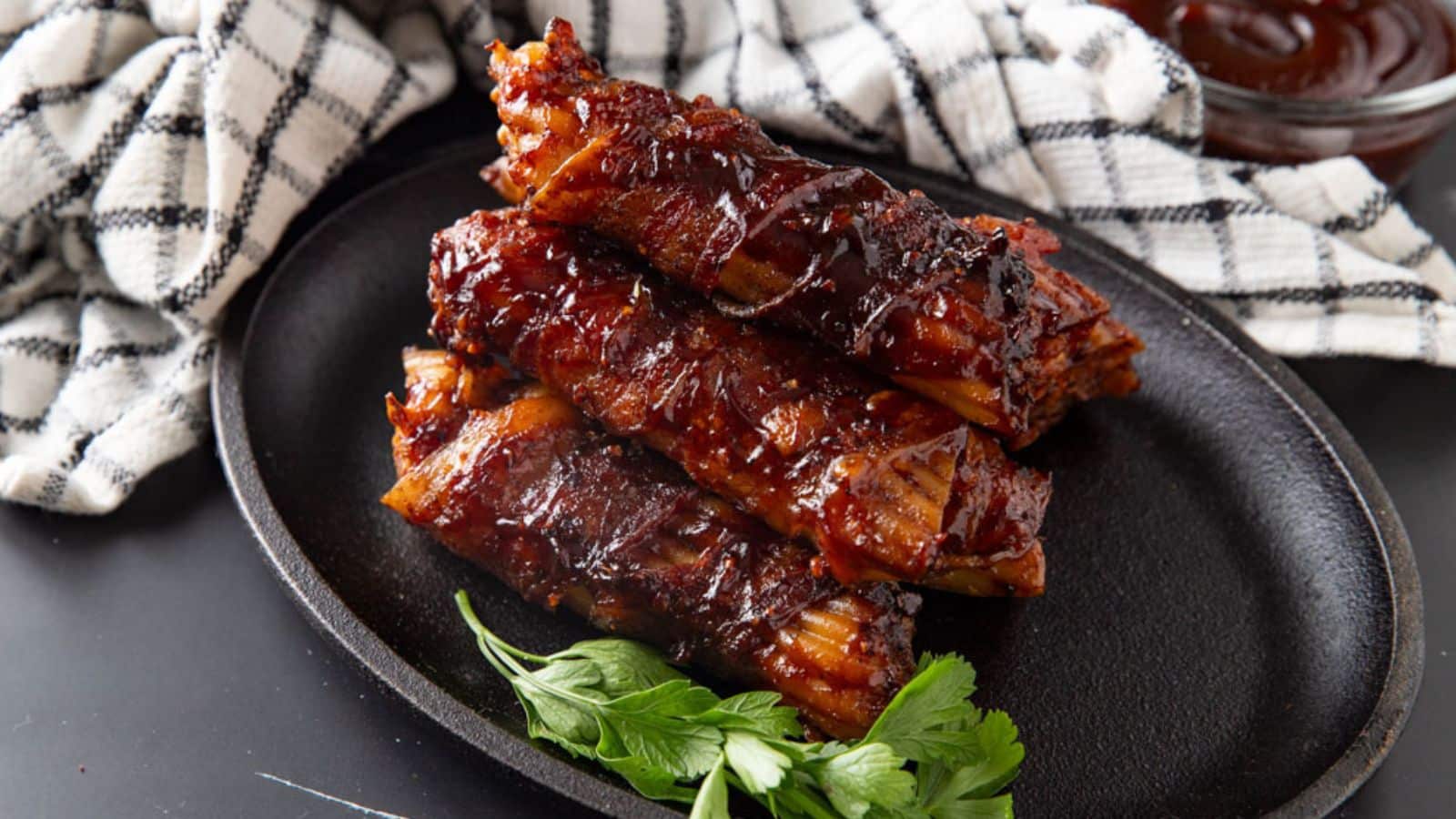 Smoked manicotti shells filled with meat on a black plate