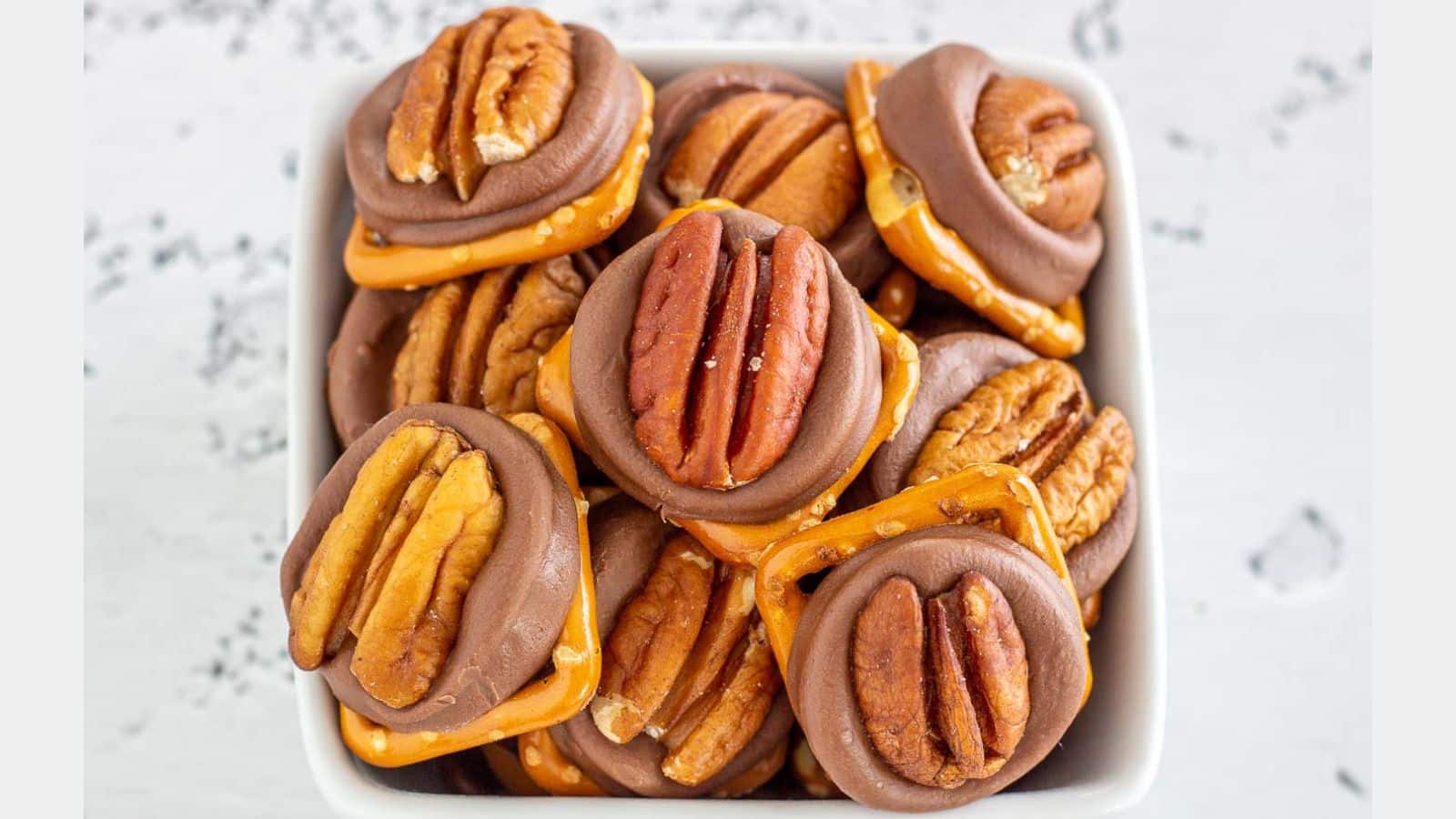 Pretzels with rolos and pecans stacked in a bowl