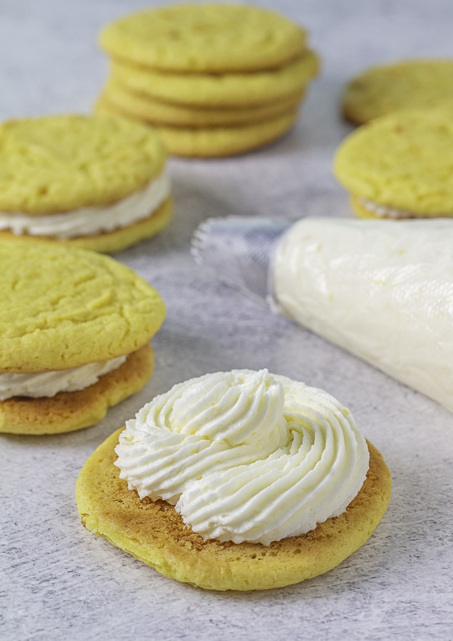 Lemon frosting on a lemon cookie with a piping bag