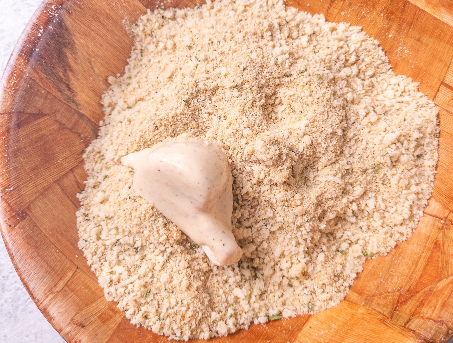 Battered mushrooms in a bowl of breadcrumbs