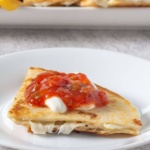 Cheese quesadilla topped with salsa on a plate