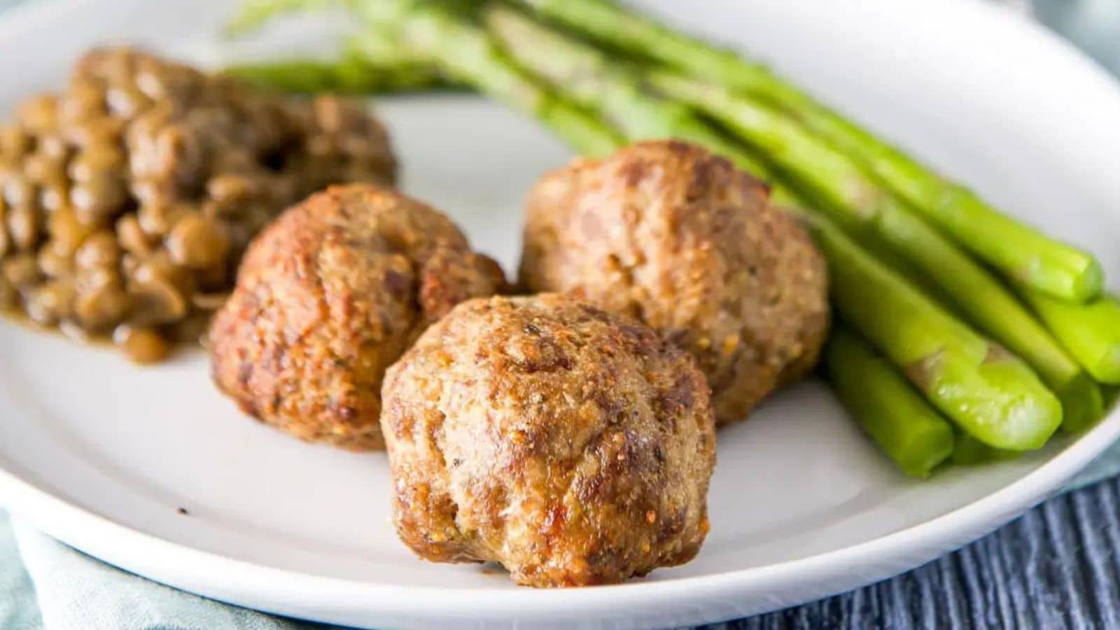 Meatballs on a plate with asparagus and lentils