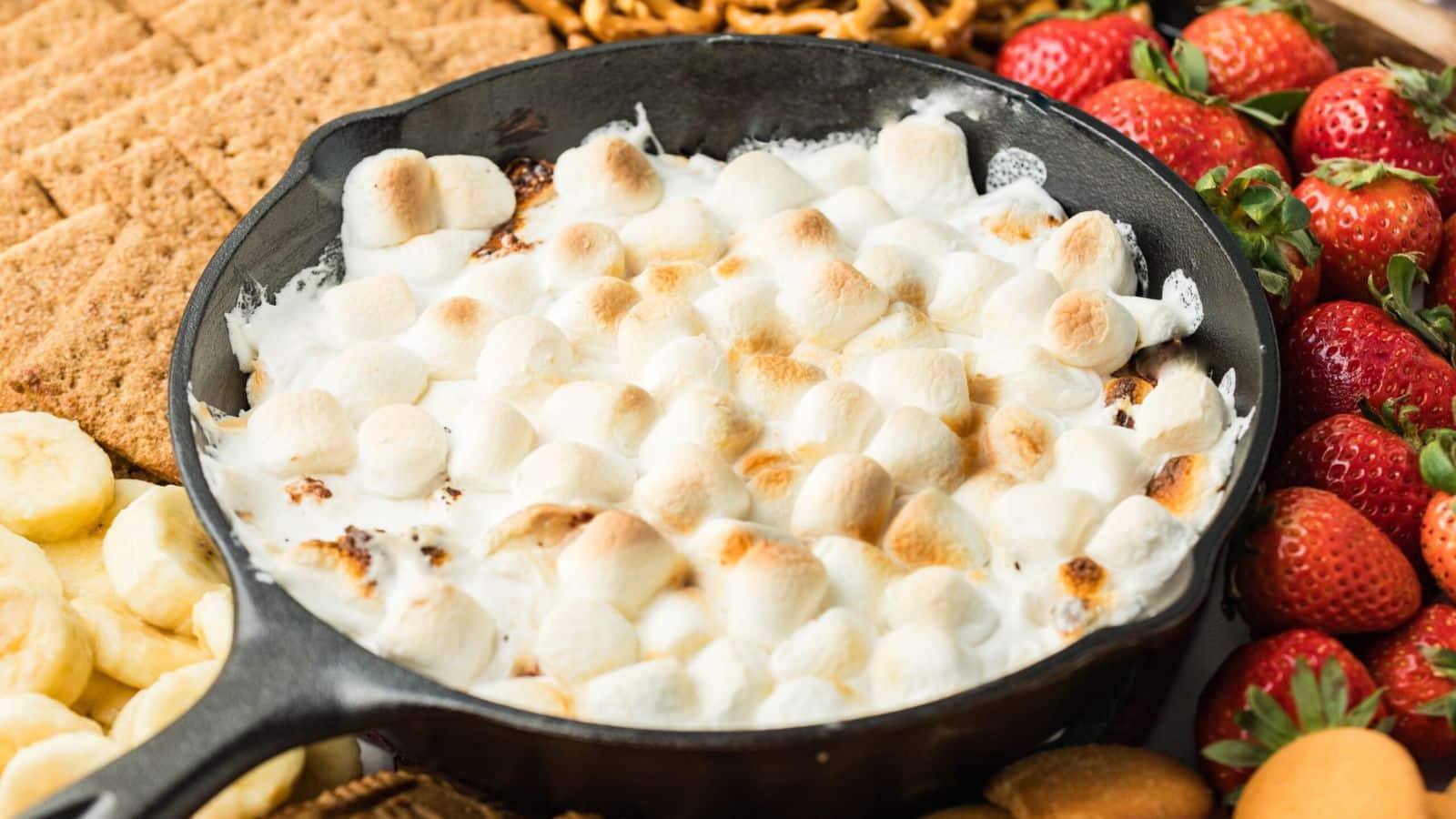 Smores Dip in a skillet setting on a charcuterie board