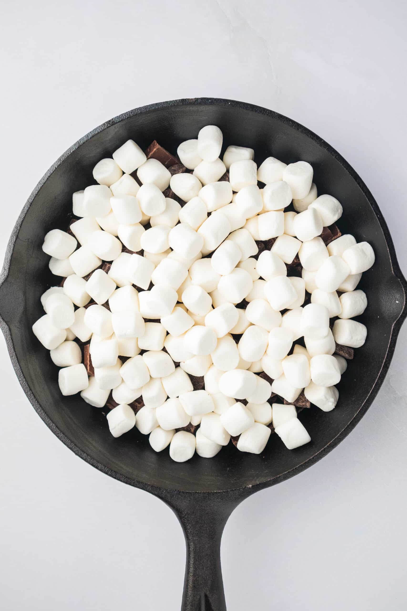 marshmallows on top of chocolate in a skillet