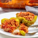 Stuffed pepper cut open on a plate with a bite on a fork