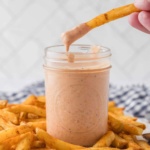 dipping fries into comeback sauce in a jar