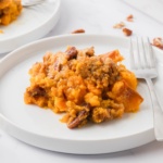 sweet potato casserole topped with pecan streusel on a plate with a fork