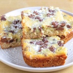 slices of gooey butter cake with chocolate chips stacked on a white plate