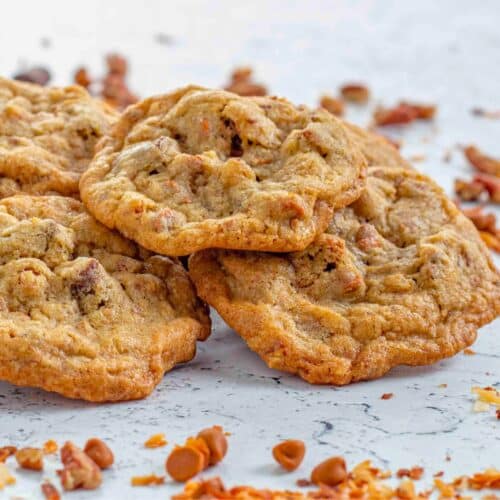 cinnamon chip cookies surrounded by toasted coconut cinnamon chips chocolate chunks and nuts