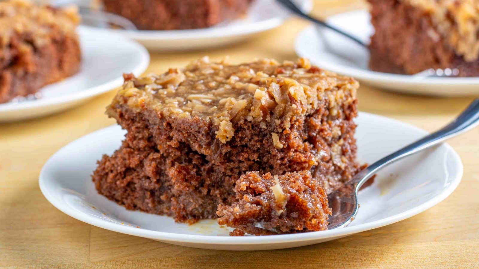 German chocolate poke cake slice on a plate with a fork